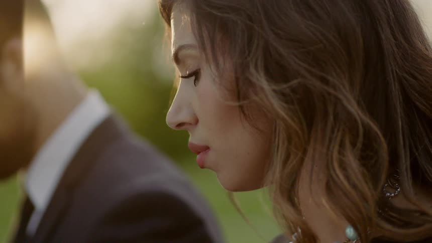 A woman is looking down at something with a sad look