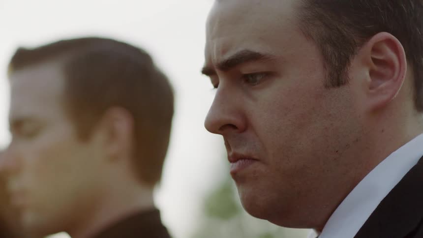 Two men are standing next to each other with sad looks on their face
