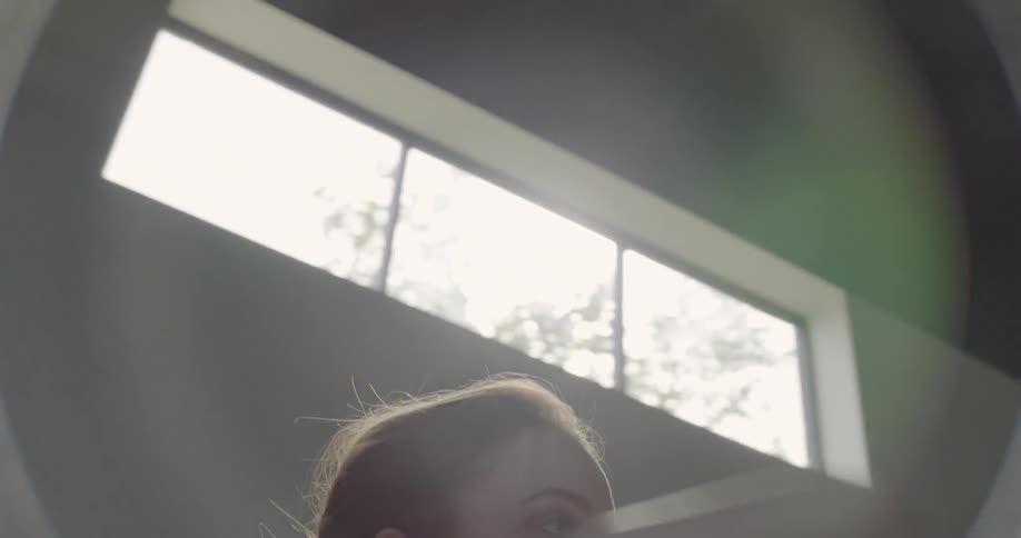 Dancer next to window moving arms above her head