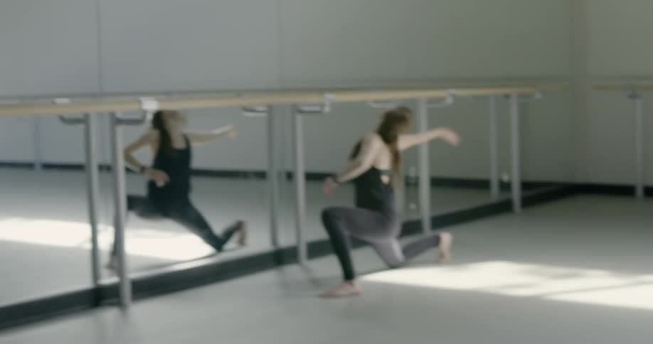 A woman is dancing in front of a mirror