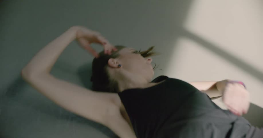 A woman is dancing while laying on the ground