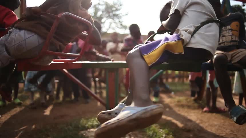 Children play on a merry go round during the day time