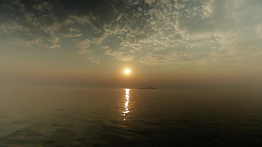 Calm waters with the sun setting in the distance