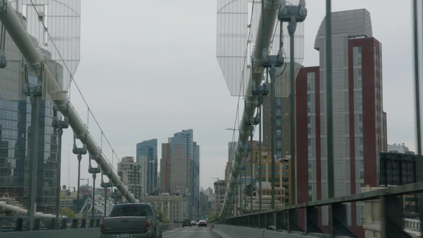 Driving along suspension bridge in city
