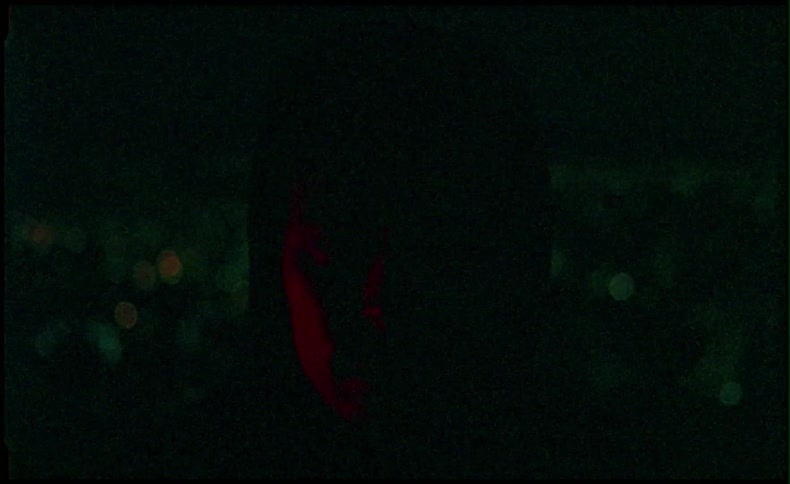 Man stands outside in a city at night