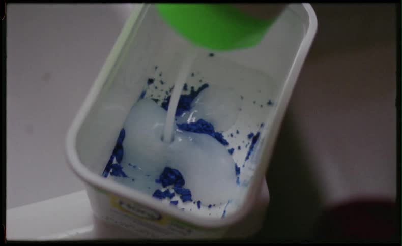 Woman mixing blue powder in tub