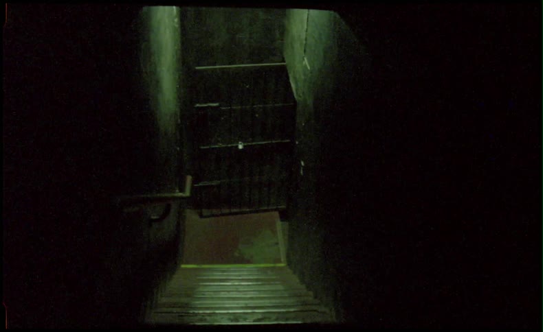 A dark stairwell leads to a door