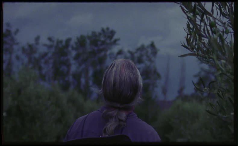 Woman standing on a hill looking off of a mountain
