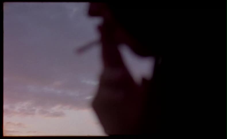 A man smokes a cigarette on the beach
