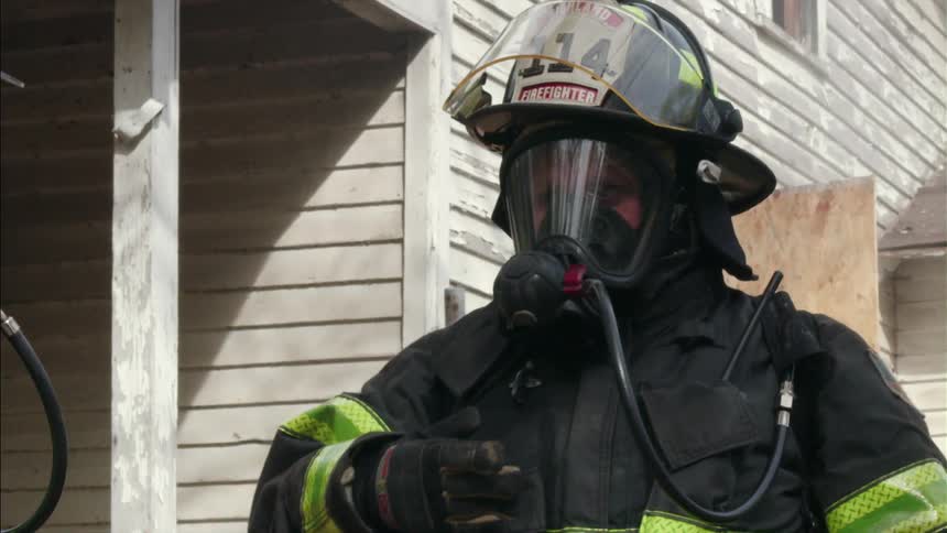 Firemen standing outside a house in full gear
