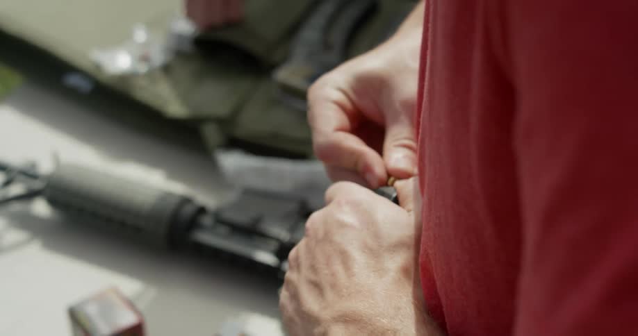 A man loads an assault rifle magazine