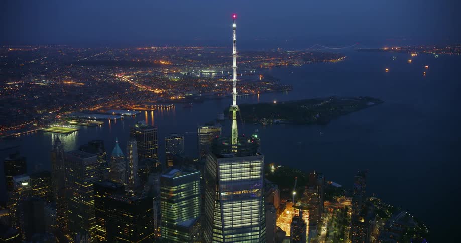A tall city tower illuminates the night sky