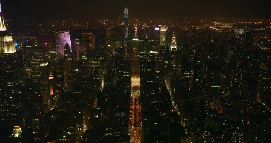 Tall city buildings illuminate the night sky