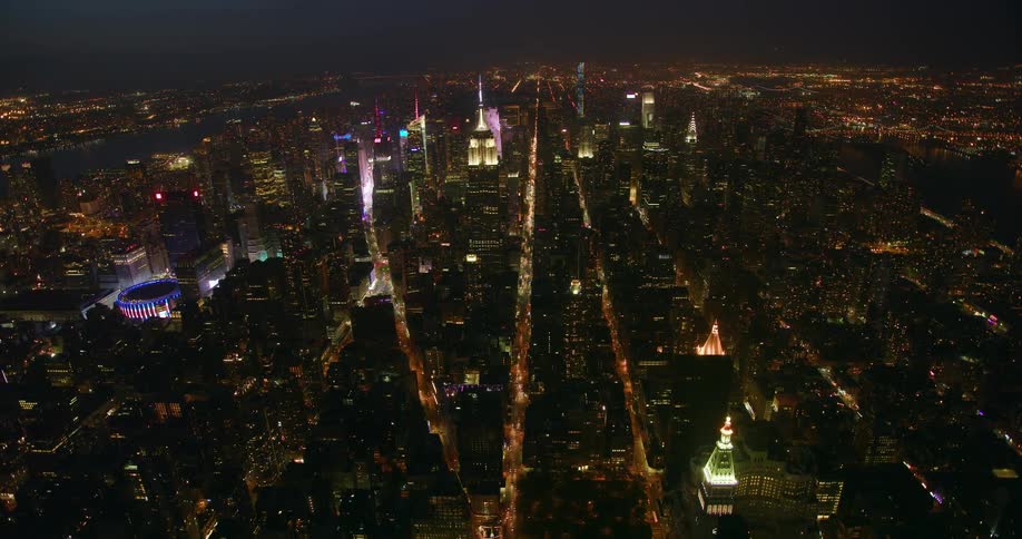 Tall city buildings illuminate the night sky