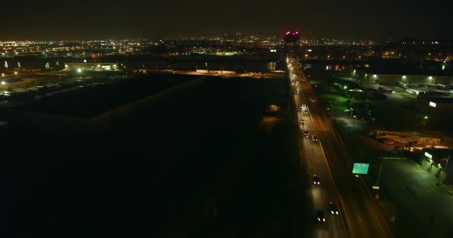Vehicles travel along a city bridge at night