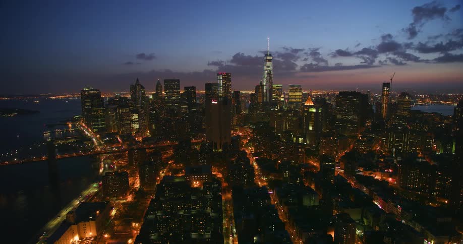 Aerial view of a large city at sunset next to water