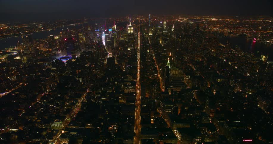 Tall city buildings illuminate the night sky
