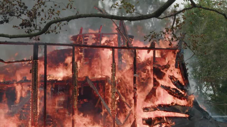 A wall frame remains as a house burns