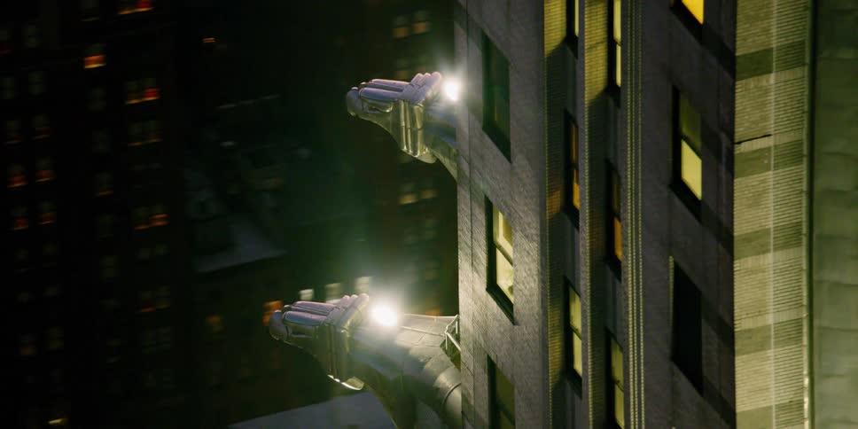 Gargoyles extend from the side of a tall city building