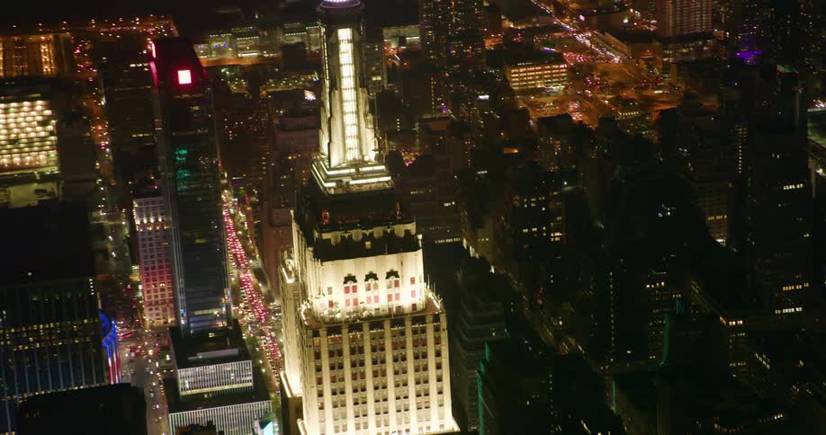 A tall city tower illuminates the night sky