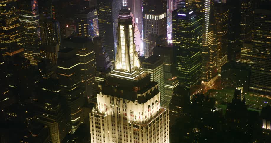 A city tower illuminates the night sky