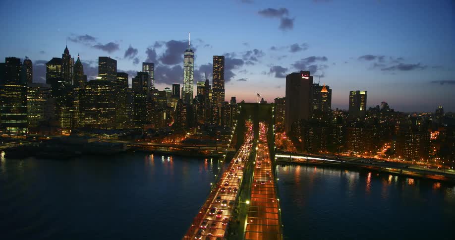 A well lit bridge leading to a city