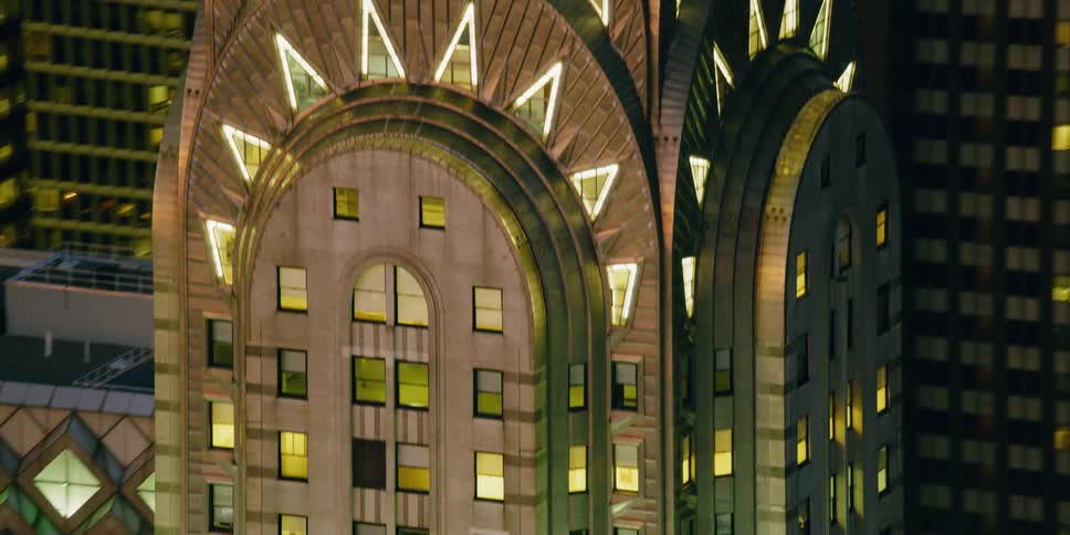 A tall city tower illuminates the night sky