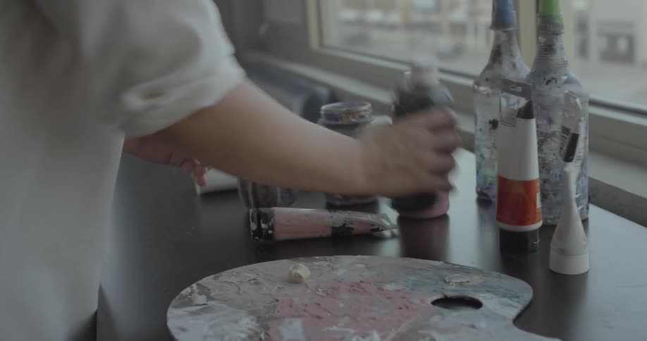 Woman squirts some paint out onto a paint pallet