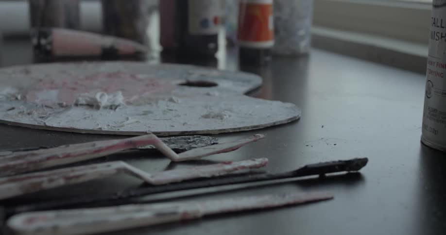 Painting tools rest on a table next to a pallet