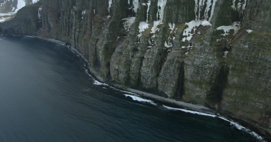 Water flows towards the side of a tall mountain