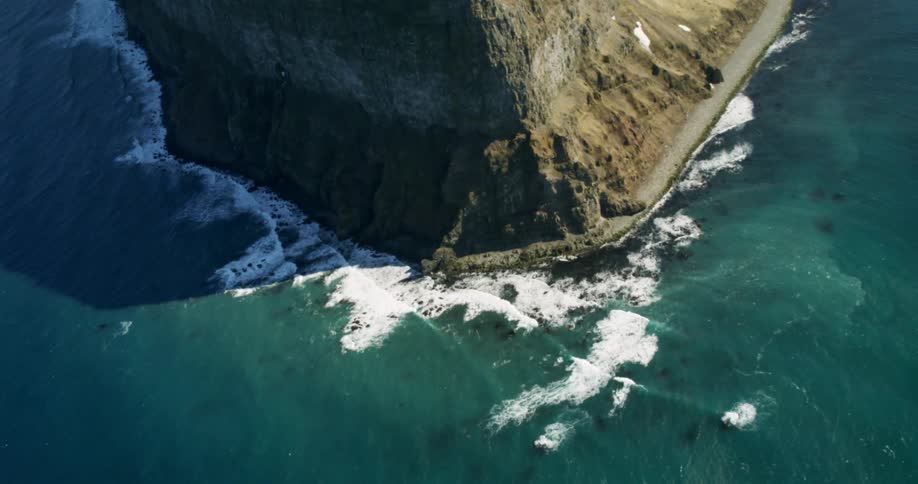 Waves flow towards the tall cliffs