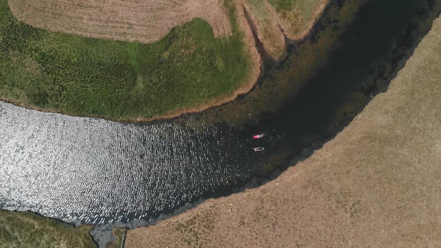 Two people kayak on a river