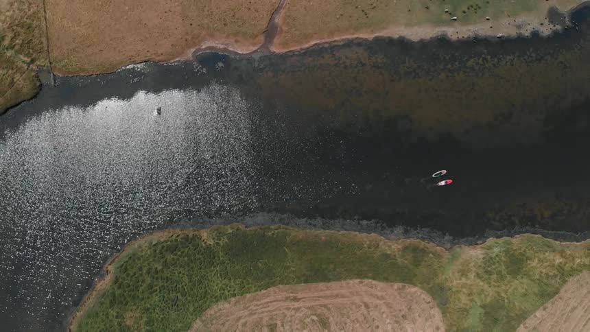 Kayakers float on a river on a sunny day