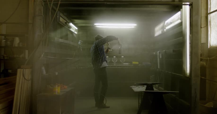 Someone is spraying paint onto something in a garage