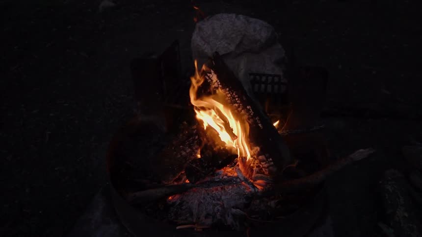 A campfire burns at night
