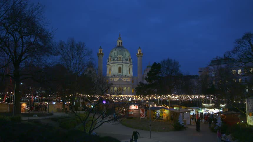 People wander through a market in a european city at night