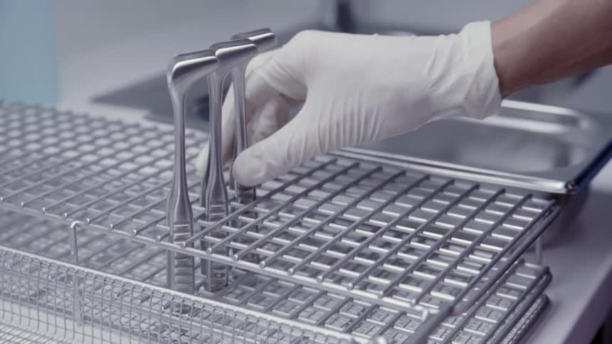 A person places tools in a drying rack