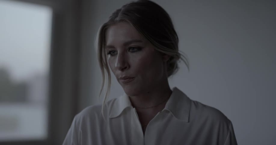 A woman thinks intently by windows