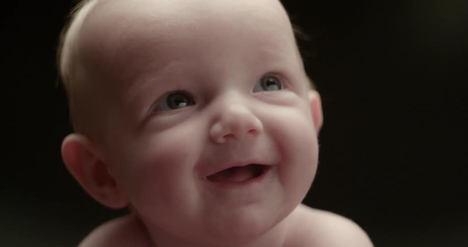 A baby is smiling and looking up
