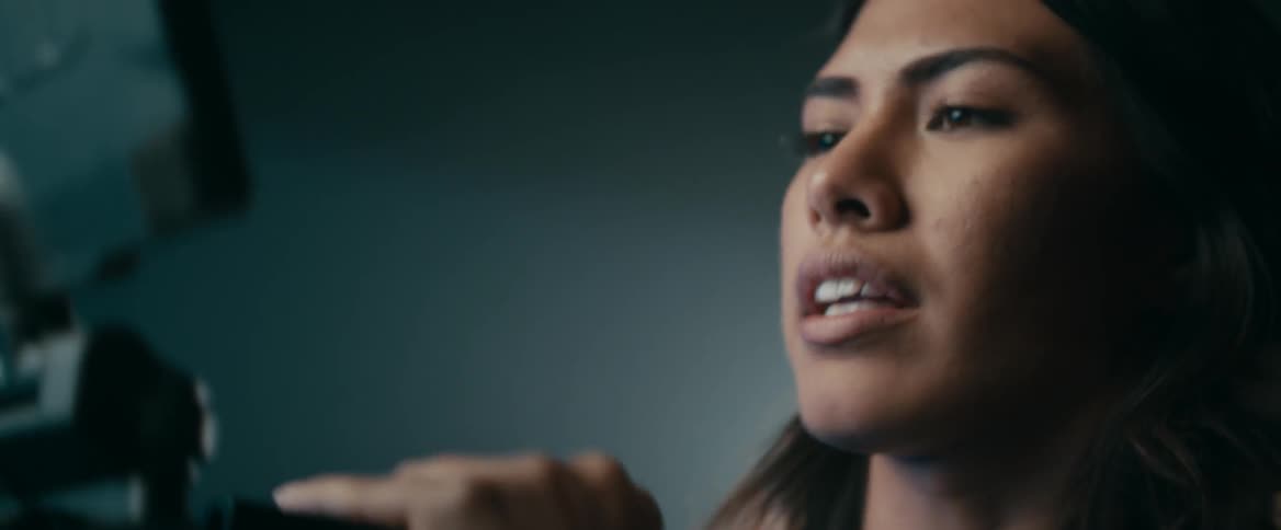 A woman is talking to someone as she lifts something up