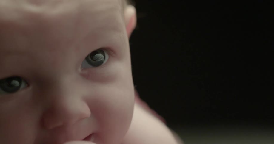 A baby chews on his fingers