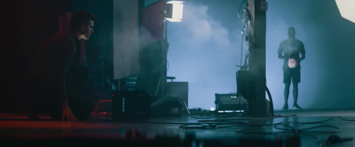 A man adjusts a smoke machine at a photoshoot
