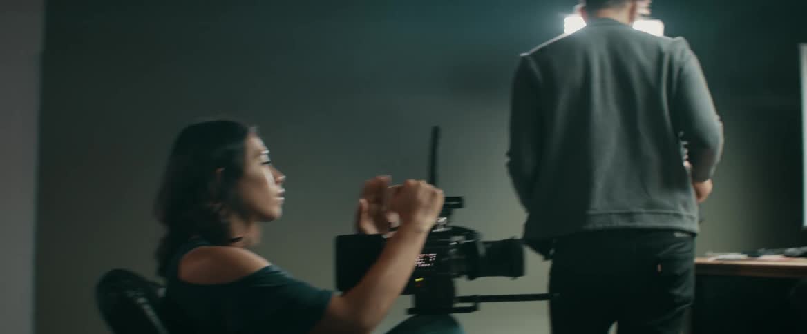 A female director adjusts a camera before filming