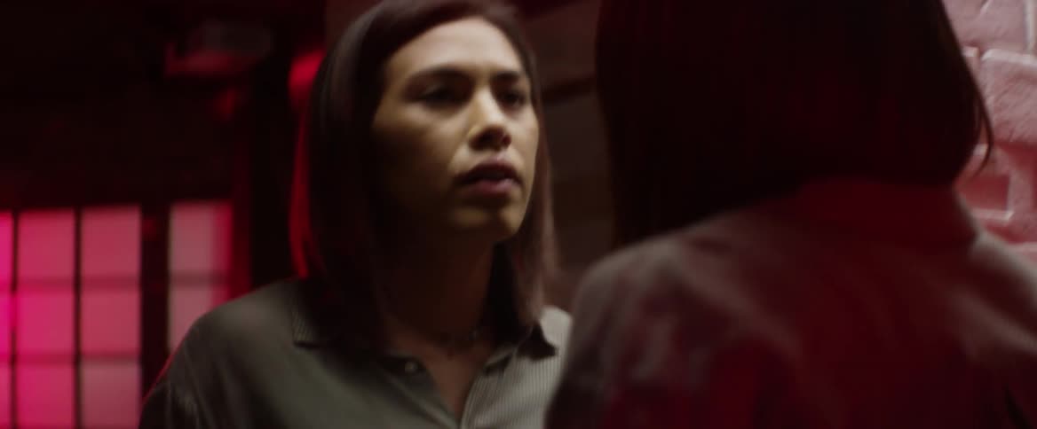 A woman gathers herself and looks in a mirror