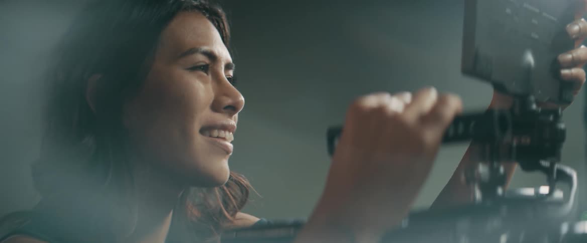 A woman smiles while filming