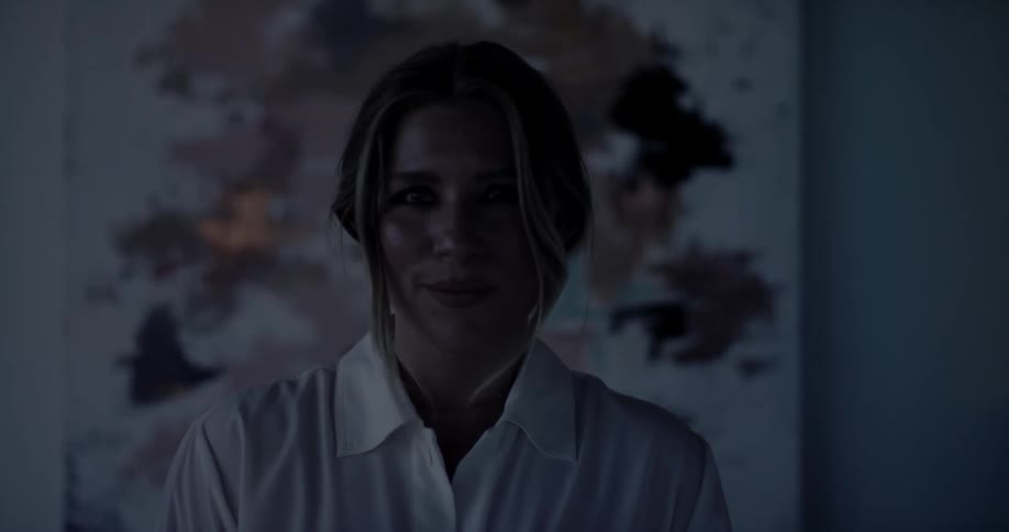 A woman stands in front of a painting