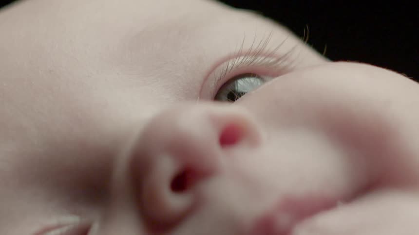 An infant lays and looks upward