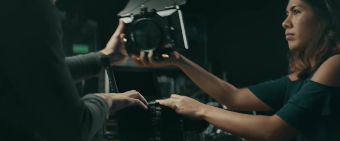 A man and woman put together video filming equipment