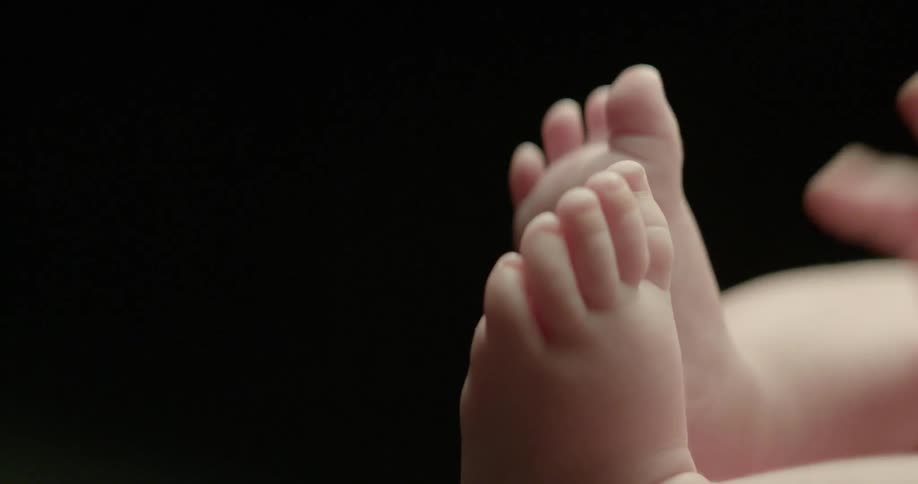 The hands and feet of a chubby baby