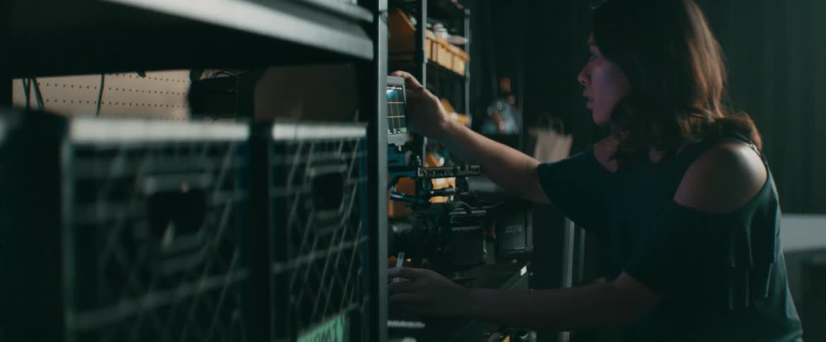 A woman enters data onto the screen of a movie camera